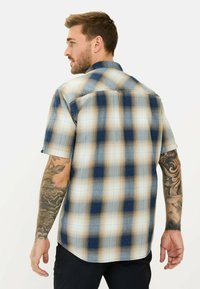 Kurzarm-Karohemd in Blau- und Beigetönen, mit klassischem Kragen, Knopfverschluss und einem lässigen Schnitt mit abgerundetem Saum.