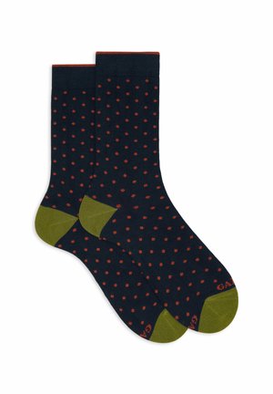 Calze blu Navy con piccole pois arancioni, talloni e punte verde oliva, e bordatura arancione sulla parte superiore.