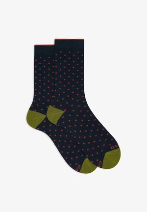 Navy blue socks with small orange polka dots, olive green heels and toes, and orange trim at the top.