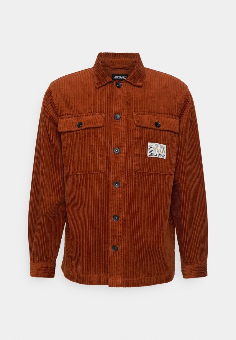 Rostfärgad corduroy skjortjacka med krage, två bröstfickor och knäppning. Har en märke på den vänstra fickan.