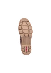 Semelle de chaussure marron avec des rainures et des crêtes texturées, arborant un logo rose au centre. Le matériau semble être du caoutchouc avec une finition mate.