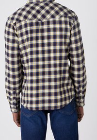 Langemouwen ruitjesoverhemd met gele, blauwe en bordeauxrode controles, voorzien van een klassieke kraag en knopenmanchetten. Zachte stof met een aansluitende pasvorm.