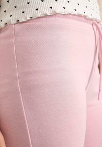 Lichtroze joggingbroek van een zachte katoenmix, met een trekkoord in de taille en een gladde textuur, uitgevoerd in een aangesloten model.