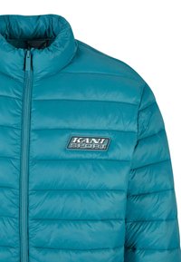 Jachetă puffer teal cu guler înalt, închidere cu fermoar și cusături orizontale. Prezintă un logo "KANI SPORT" pe piept. Textură netedă.