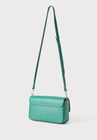 Green leather crossbody bag with a rectangular shape, fold-over flap, adjustable strap, and gold hardware accents. Subtle textured surface.