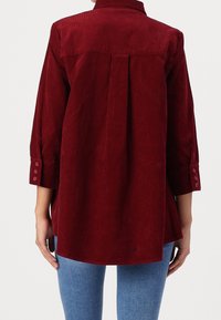 Bordeaux corduroy overhemd met een achterplooien, een omgeslagen kraag en knoopmanchetten, met een langere zoom en een gestructureerde stof.
