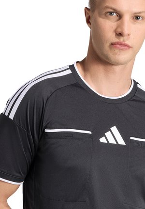 Junger Mann trägt ein schwarzes Adidas-Sportshirt mit weißen Streifen auf den Schultern und Logo auf der Brust, Bildausschnitt am Hals und Arm.
