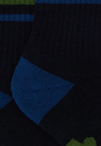 Calze nere con strisce blu e verdi, texture a costine e sezioni di tallone e punta blu a contrasto.