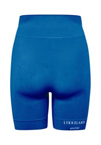 Blaue Radlerhose mit hoher Taille und dem Schriftzug "LYKKELAND ateliér" auf dem unteren rechten Bein.