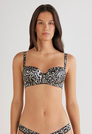 Soutien-gorge à imprimé léopard avec bonnets moulés, bordures noires, bretelles ajustables et finition satinée lisse. Le design met l'accent sur la forme et le soutien.