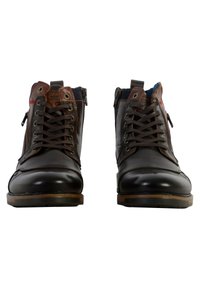 Botas de tobillo de cuero marrón con cordones en la parte delantera, cremalleras laterales y forro azul en contraste. Textura suave con suelas de goma marrón.