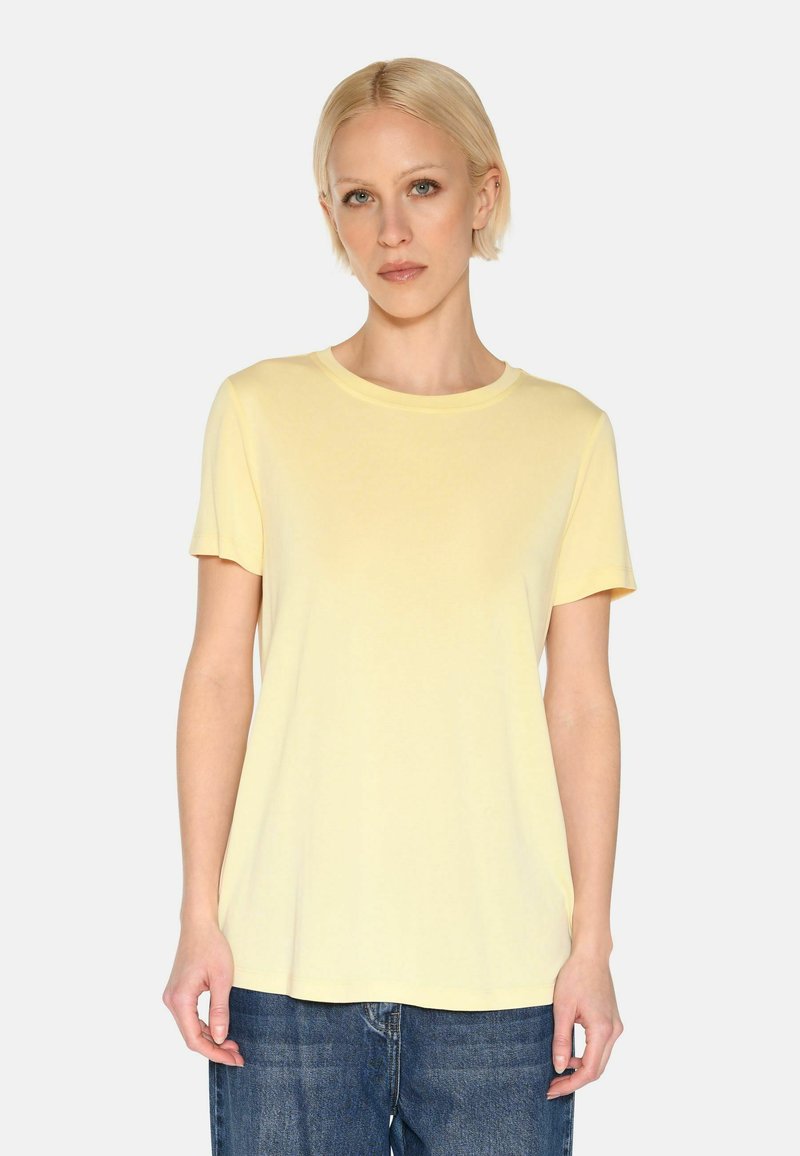 Lichtgele katoenen t-shirt met een ronde hals, korte mouwen en een relaxed fit, gecombineerd met blauwe denim jeans.