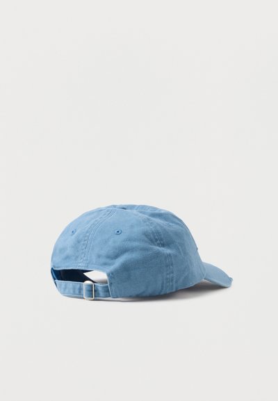 Zils kokvilnas beisbola cepures ar izliekto vizieri, regulējamu siksniņu aizmugurē un izšūtām detaļām uz krona. Tekstūrēta auduma apdare.