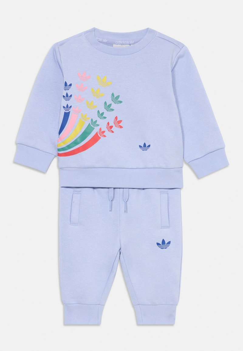 Svijetloplavi dukserica i odgovarajući kompletnu jogger set, s višebojnom grafikom lišća. Materijal je mekan; joggeri imaju vezicu i džepove.