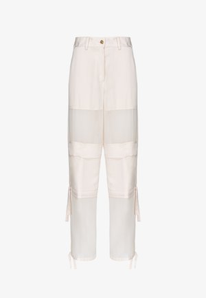 Białe spodnie z wysokim stanem, zapinane na guziki, z przezroczystymi wstawkami na udach i łydkach oraz regulowanymi troczkami na dole nogawek.