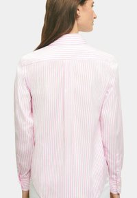 Lichtroze en witte gestreepte blouse met lange mouwen, knoopmanchetten en een rugpasdetail, dat een gladde stoftextuur laat zien.