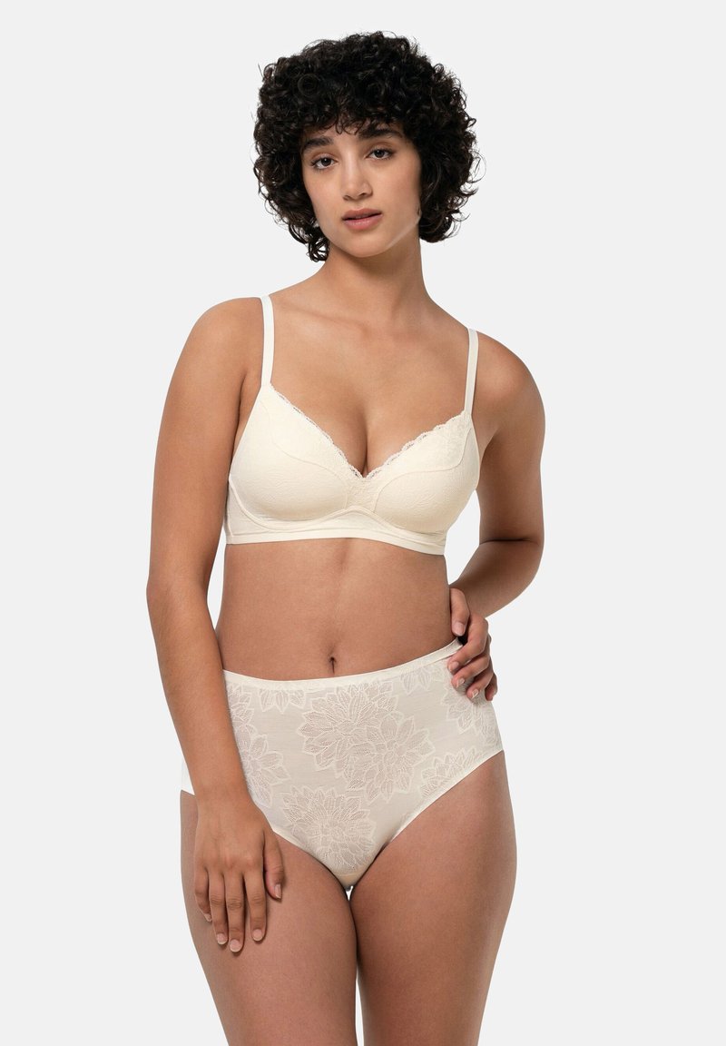 Biustonosz w kolorze kremowym z delikatną koronkową lamówką i kwiatowymi wzorami. Majtki z wysokim stanem o podobnym kwiatowym wzorze, oba wykonane z gładkiego materiału.