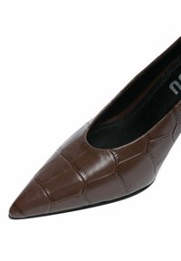 Décolleté marrone con punta appuntita, caratterizzata da un motivo effetto coccodrillo testurizzato, materiale liscio e silhouette elegante con interno foderato in nero.