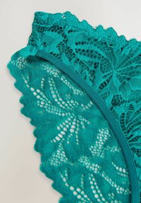 Teal mežģīņu apakšbikses ar sarežģītiem lapu līdzīgiem rakstiem, viļņotiem malām un mīkstu elastīgu jostu komfortam.