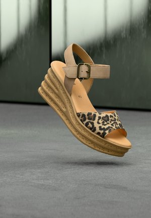 Beige sleehaksandaal met luipaardprint band, verstelbare enkelgesp, en textuurs zool, verhoogd ontwerp en open teen.