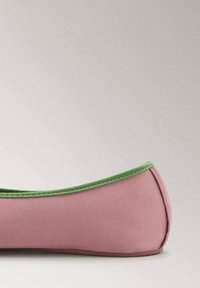 Pink ballet flat with green trim and a smooth texture, shown from the side on a neutral background.