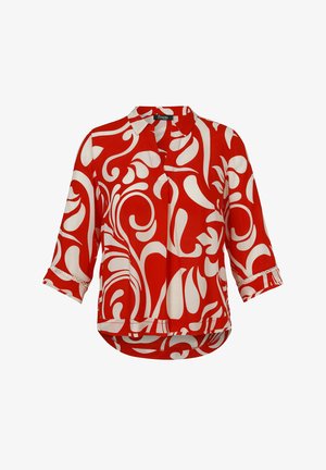 Blouse rouge avec motif tourbillonnant abstrait blanc, manches trois-quarts et col avec détail de manchette boutonnée.