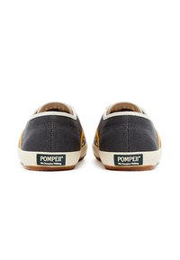 Graue Leinen-Schuhe mit akzentuiertem, gelbem Wildleder, cremfarbenen Gummisohlen und einem grünen "POMPEII"-Label auf der Rückseite. Verfügt über ein niedriges Profil-Design.