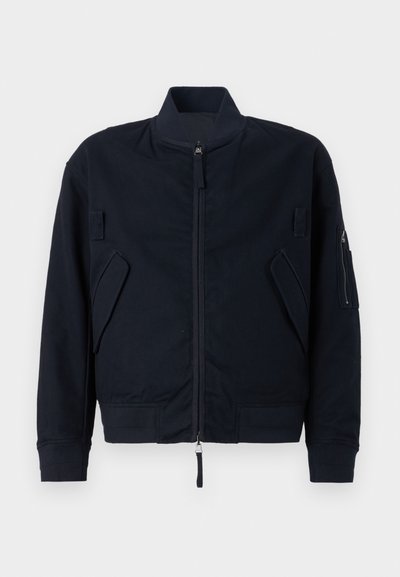 Navy bomber jacket made of textured fabric, featuring a zip closure, stand-up collar, and multiple utility pockets on the front and sleeves.