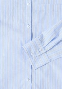 Camicia a righe blu chiaro, maniche lunghe, con bottoni sul davanti e taschino sul petto. Presenta bottoni bianchi e sottili righe verticali.