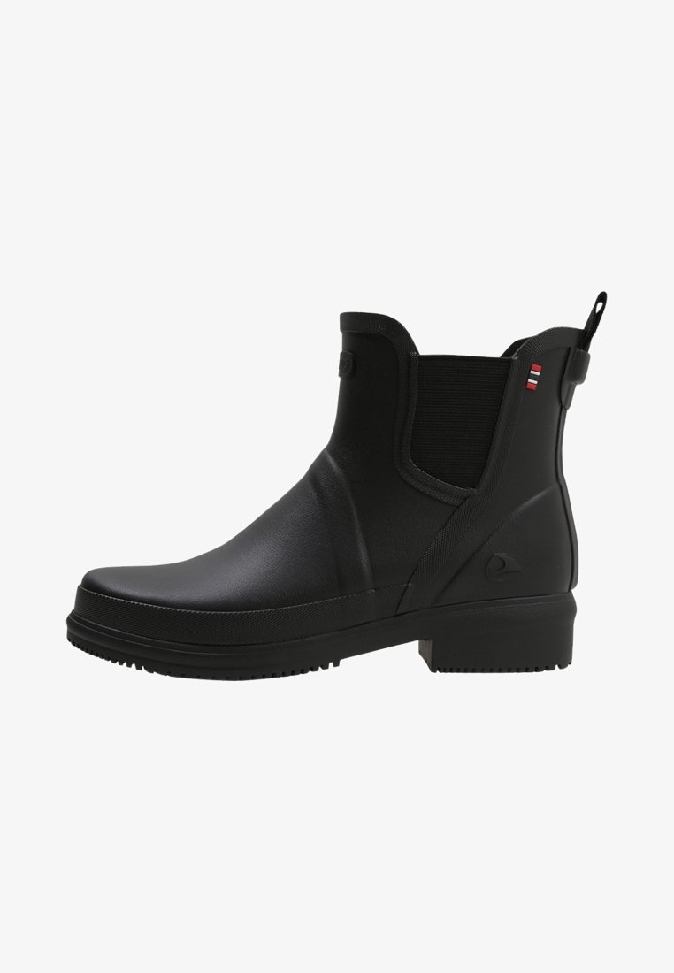 Botte de pluie noire chevillée avec panneaux latéraux élastiques, languette, talon bas et logo discret près du talon.