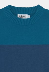 Stickad tröja i teal och mörkblå ränder, med ribbad halsringning och texturerad tyg. Märket synligt med "Molo"-logotyp.