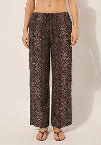 Pantalones de pierna ancha con estampado de serpiente marrón y cintura con cordón, confeccionados en un material ligero y con un ajuste relajado, ideales para un uso casual.
