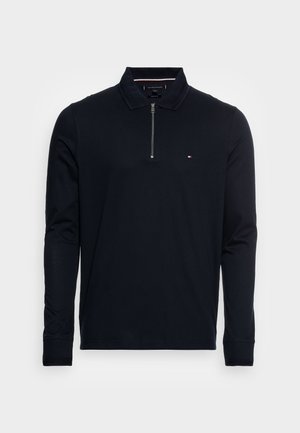 Czarna koszulka polo z długim rękawem, z suwakiem na ćwiartkę, ściągaczami na mankietach i kołnierzyku oraz małym logo Tommy Hilfiger na lewej piersi.