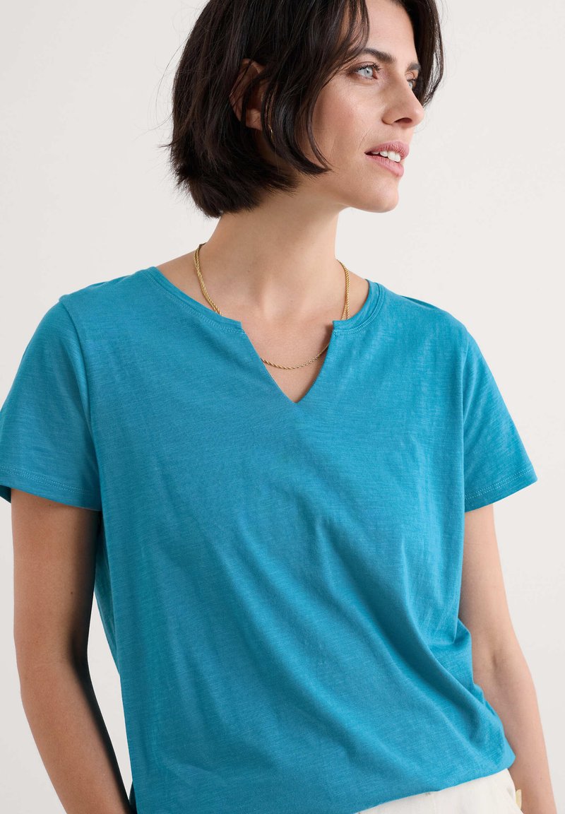 Kurzarm-V-Ausschnitt-T-Shirt in strahlendem Blau, aus weichem Stoff mit lockerer Passform; bietet minimale Details und eine glatte Textur.