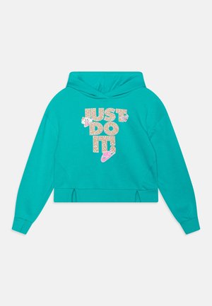 Turkusowa bluza z kapturem z napisem "JUST DO IT" w beżowe i białe wzory, grafiką uśmiechniętej twarzy oraz różowym logo Nike swoosh na przodzie.