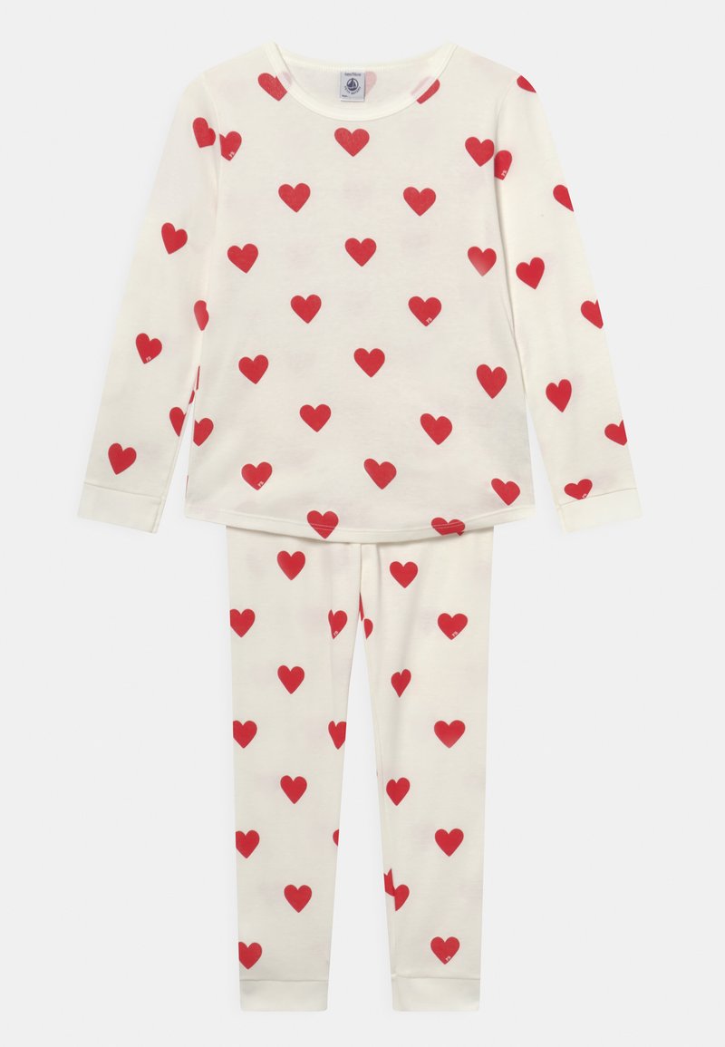 Ensemble de pyjama en coton comprenant un haut à manches longues et un pantalon, tous deux de couleur crème avec des imprimés de cœurs rouges, un col arrondi et des poignets ajustés.