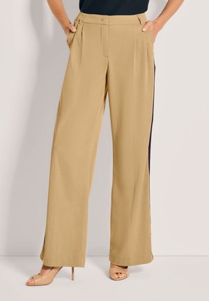 Beige wijde broek met plooien, zijzakken en contrasterende navy zijstrepen. Glad stof met een lichte glans, voorzien van een ontspannen pasvorm.