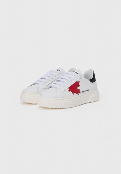 Baskets en cuir blanc avec un logo de feuille d'érable rouge, des accents noirs au talon et des lacets blancs. Semelle épaisse crème avec une accroche texturée.