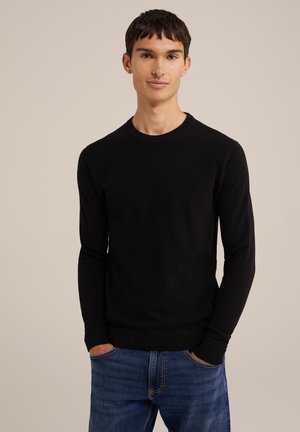 Black long-sleeve sweater with a crew neckline and ribbed cuffs, featuring a textured pattern, paired with blue denim jeans.