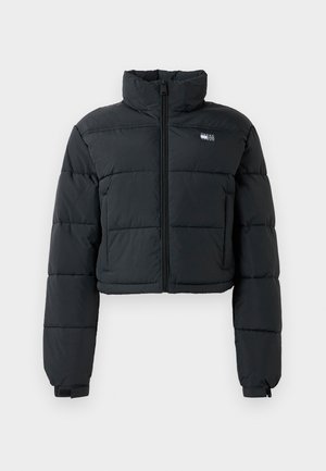 Svart kort pufferjakke med høy krage, frontglidelås og sydd seksjoner; har en liten merkeetikett på brystet.