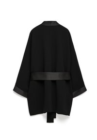 Giacca in stile kimono nera con colletto e polsini in raso, caratterizzata da un corpo ampio e testurizzato e una cintura legata in vita.