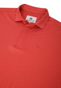 Rød polo-shirt lavet af bomuld med krave, tre-knaps lukning og et lille broderet logo. Glat tekstur med en ensfarvet farve.