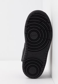 Sola de sapato de borracha preta com padrões circulares, texto não marcante e detalhe em relevo "ALL DAY PLAY" com o logótipo da Nike.