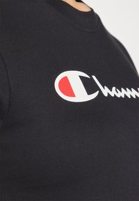 Svart bomull T-skjorte med hvit og rød logo på brystet, rund hals, og korte ermer, med en glatt tekstur.
