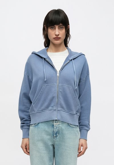 Sweat à capuche zippé bleu en tissu doux, doté d'une poche kangourou, de poignets côtelés et d'une capuche ajustable avec cordon de serrage.