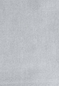 Tessuto grigio chiaro con una superficie morbida e testurizzata e un motivo diagonale. Il materiale appare liscio con leggere variazioni di tonalità.