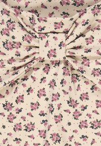 Tessuto con motivo floreale che presenta piccoli fiori rosa e verde scuro su uno sfondo crema, con un grande dettaglio a fiocco al centro.