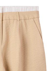Pantaloni beige realizzati in tessuto testurizzato, dotati di una cintura elastica bianca, fronte piatto e tasche laterali per funzionalità.