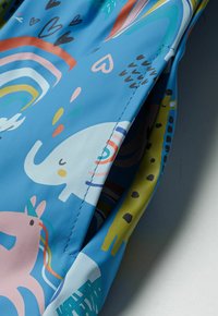 Spalvotas vaikų vandeniui atsparus audinys, kuriame vaizduojami drambliukai, vienaragiai ir vaivorykštės, mėlyname fone su kontrastingomis geltonomis detalėmis.