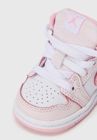 Białe i różowe trampki dla malucha z białymi sznurowadłami, perforowanym noskiem oraz różowym logo Jumpman na języku.